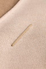 A needle on a textured fabric surface.