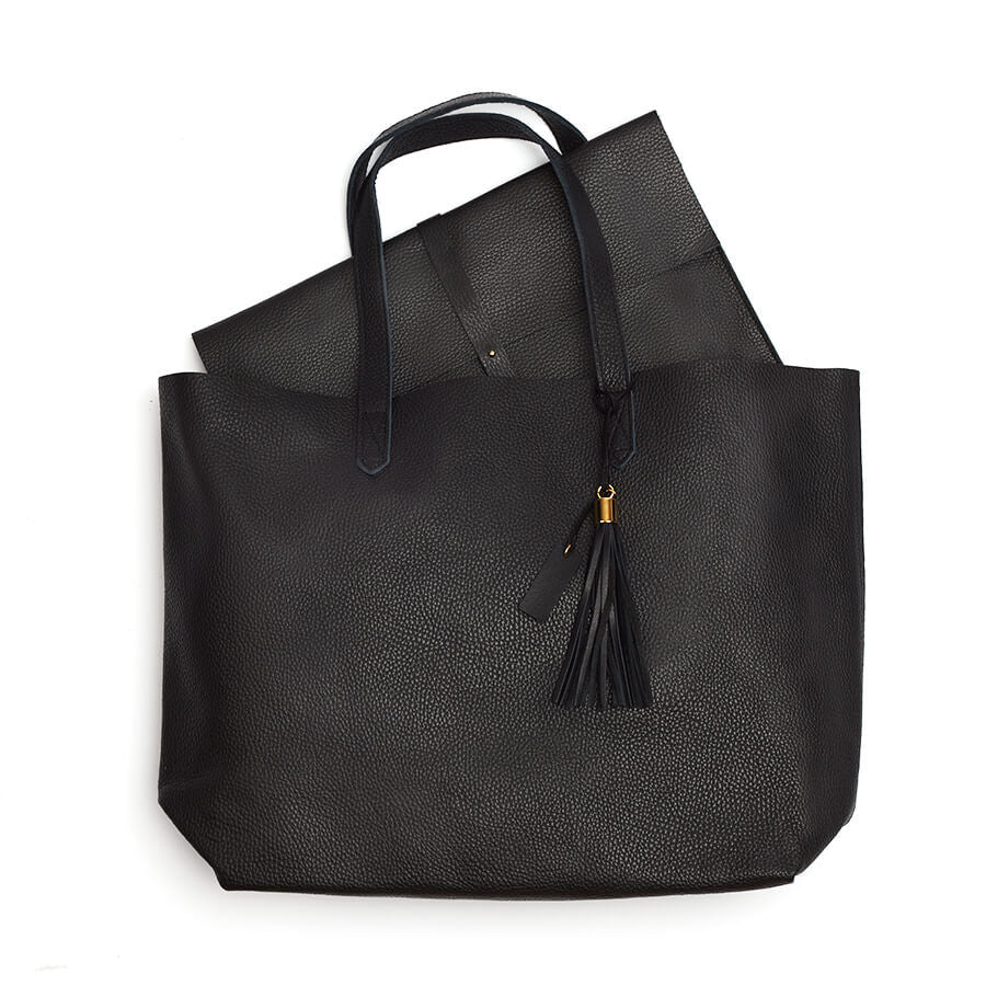 Handbag with handles and a tassel on white background.