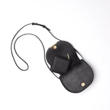 Two overlapping handbags with long straps on a plain background.