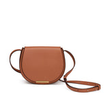 Round shoulder bag with detachable strap and metal detail on front.