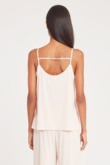 Woman seen from behind wearing a strappy top and pants.