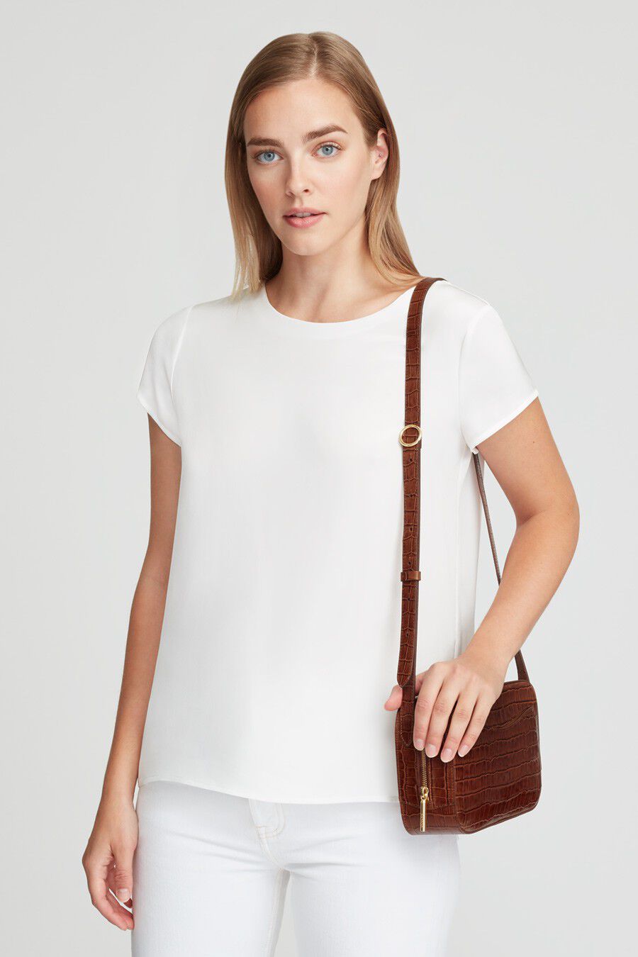 Woman with a shoulder bag standing and facing the camera.