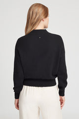 Woman in a sweater viewed from the back.
