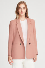 Woman wearing a blazer over a shirt, standing upright