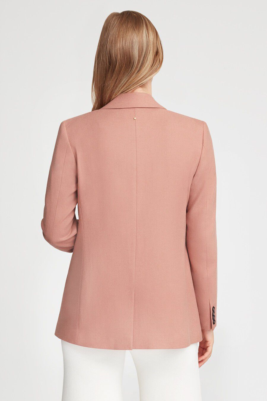 Woman viewed from behind, wearing a jacket and pants.