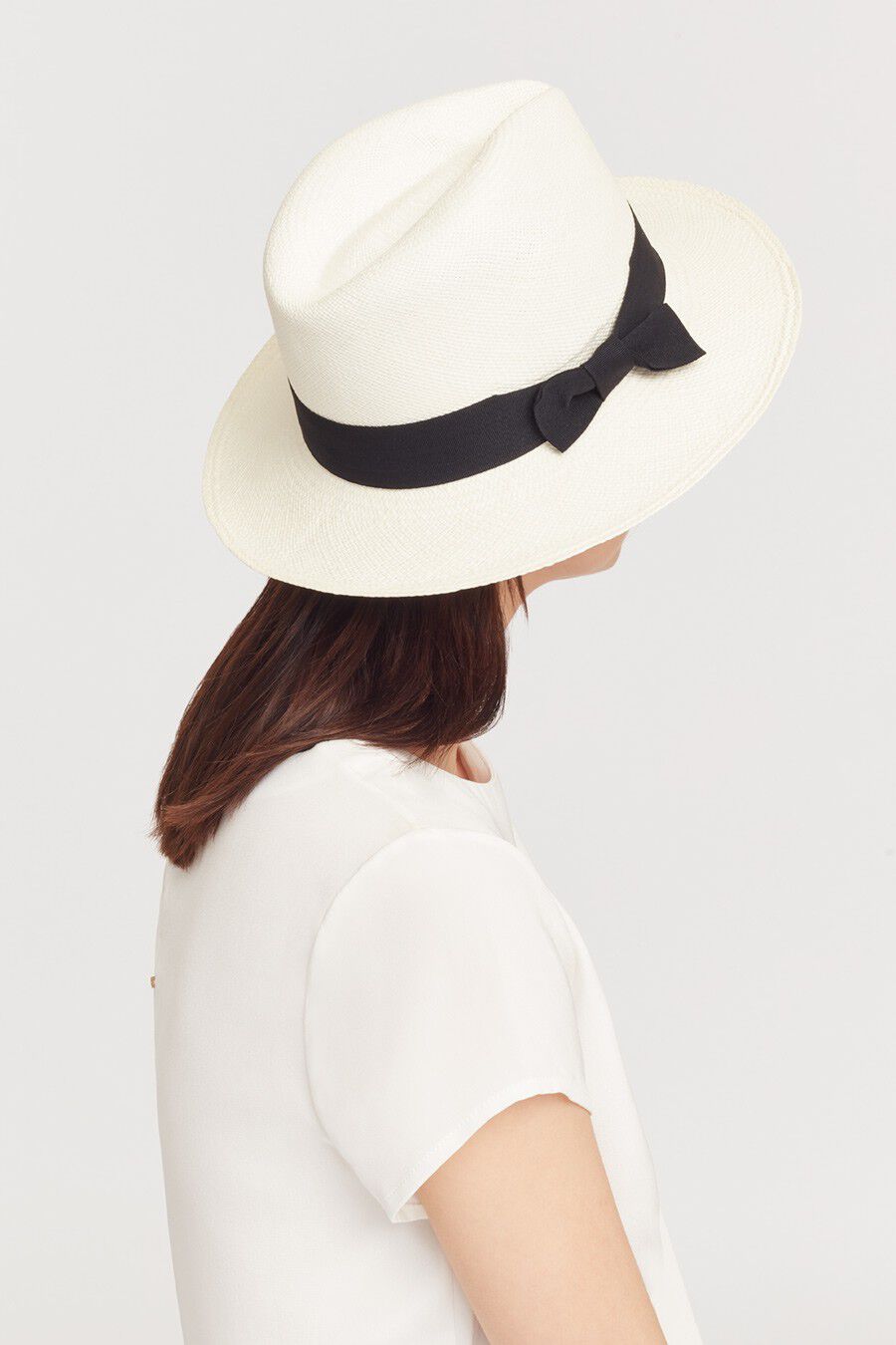 Woman wearing a hat, viewed from the back.