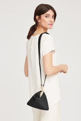 Woman looking over shoulder with a handbag hanging on her arm.