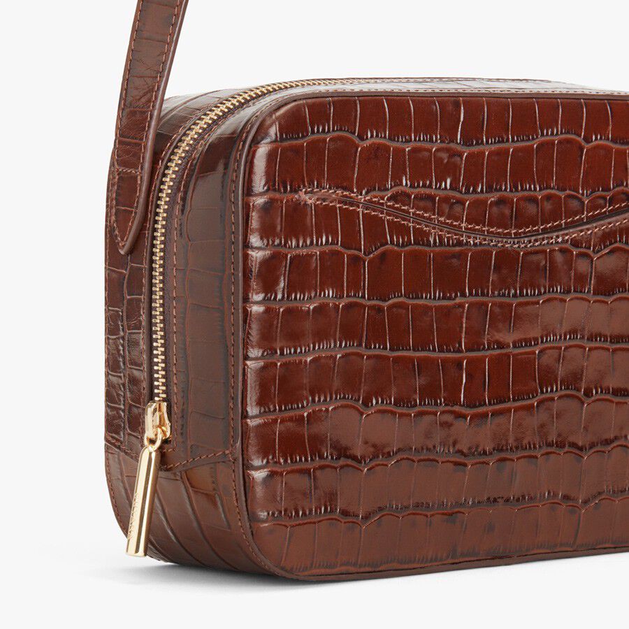 Small croc-embossed leather purse with zipper and strap.