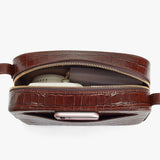 Belt bag with zipper open, showing a smartphone and notebook inside.