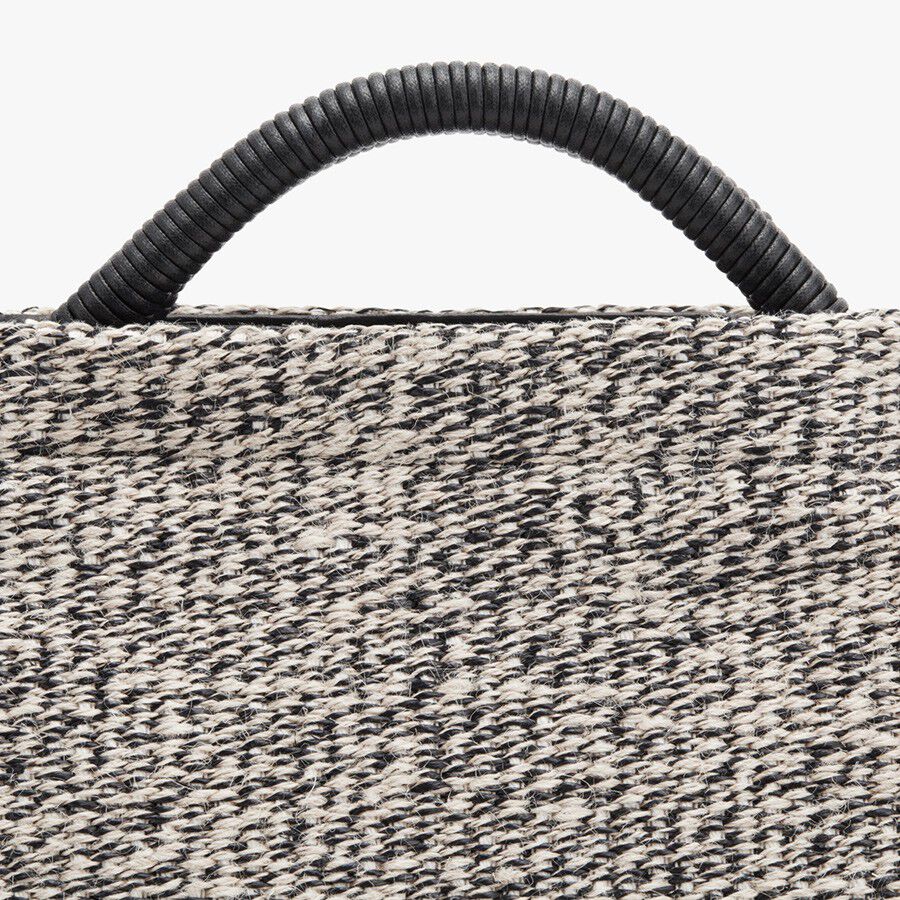 Close-up of a textured handbag with a coiled handle.