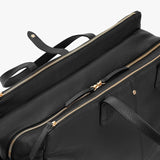Close-up view of a leather bag with multiple zippers and a handle.