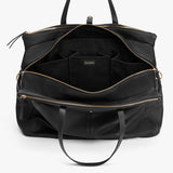 Open handbag with multiple compartments and zippers, standing upright.
