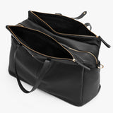 Open handbag with multiple compartments and zippers, viewed from above.
