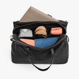 Open bag containing various personal items like clothes and shoes.