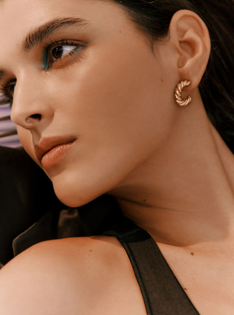 Close-up of a woman wearing an earring, looking to the side.