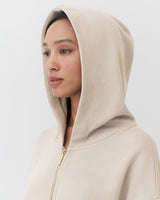 Woman wearing a hooded jacket looking to the side.
