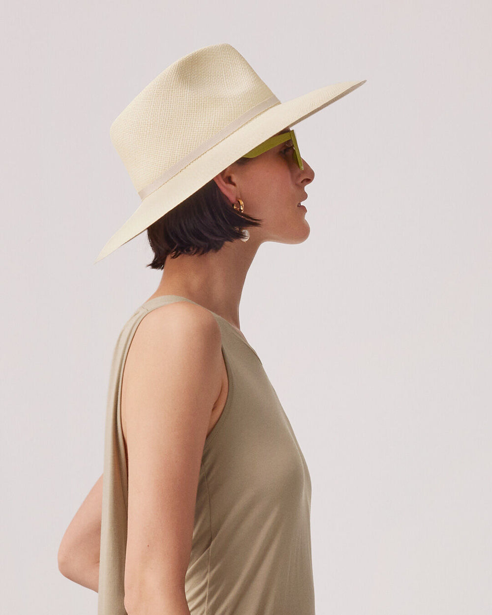 Profile of a person wearing a wide-brimmed hat and sunglasses, looking to the side.