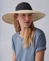Woman wearing a wide-brimmed hat and a t-shirt, looking at the camera.