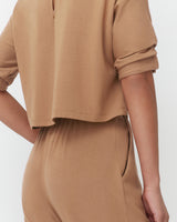Person wearing a short-sleeved top and pants, partial view from side.