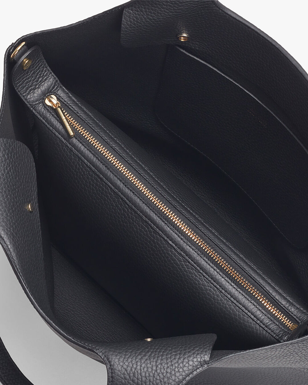 Open handbag showing inner compartment and zipper.