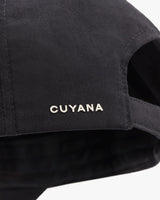 Close-up of a cap with the brand name CUYANA embroidered on it.