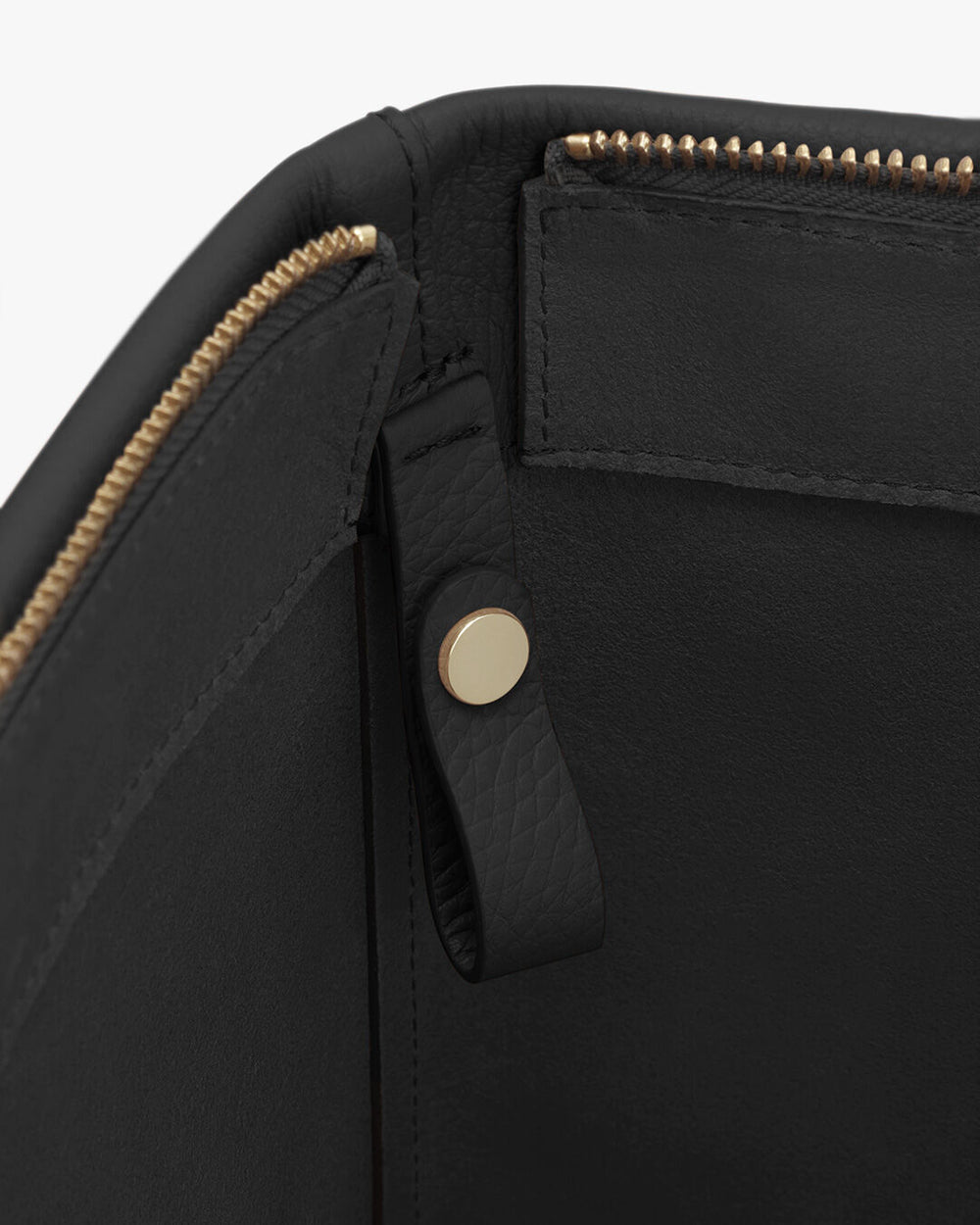 Close-up of a bag with a zipper and button detail.