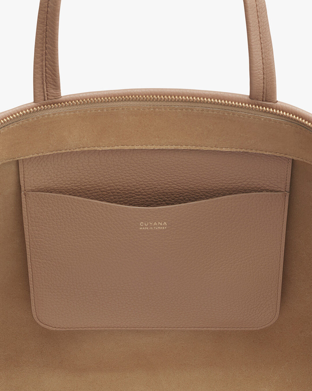 Close-up of a handbag with a brand logo and exterior pocket.