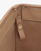 Close-up of a bag with a zipper and snap button detail.