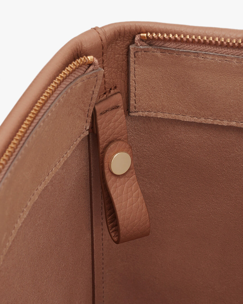 Close-up view of a bag showing zipper, stitching, and snap button detail.
