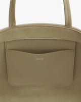 Close-up of a handbag with a front pocket and brand logo.