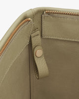 Close-up of a handbag with zipper and snap closure.