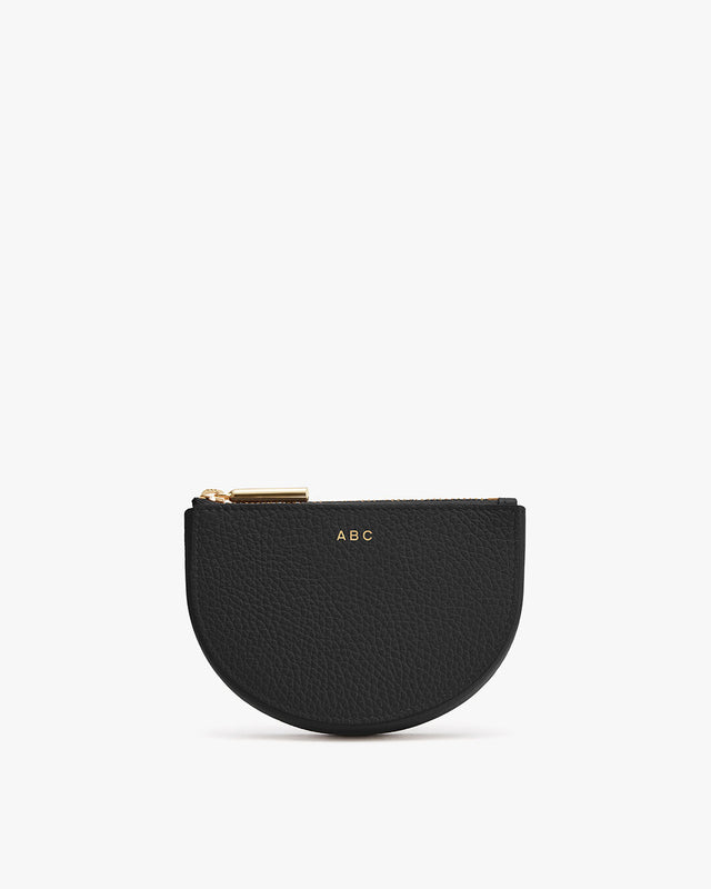 Small half-moon shaped purse with zipper and initials 'ABC' on front.