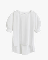 Blouse with three-quarter sleeves and layered hem on plain background.