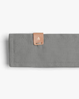 Wallet with a tab closure featuring a letter 'A'.