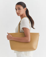 Woman holding a large bag, looking over her shoulder.