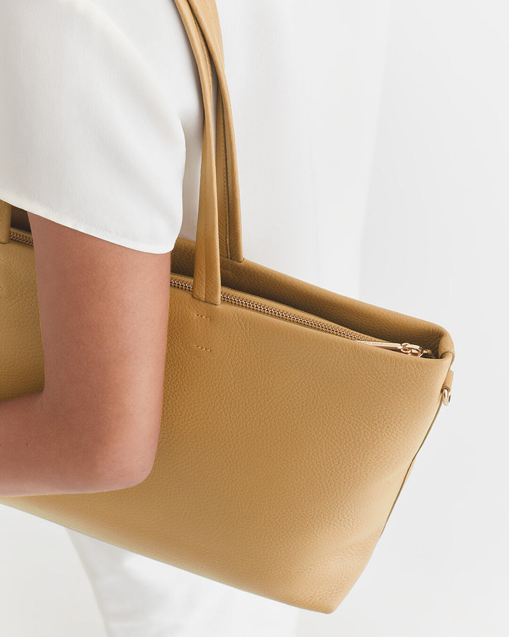 Person carrying a handbag on their shoulder.