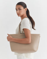 Woman looking over shoulder, holding large bag