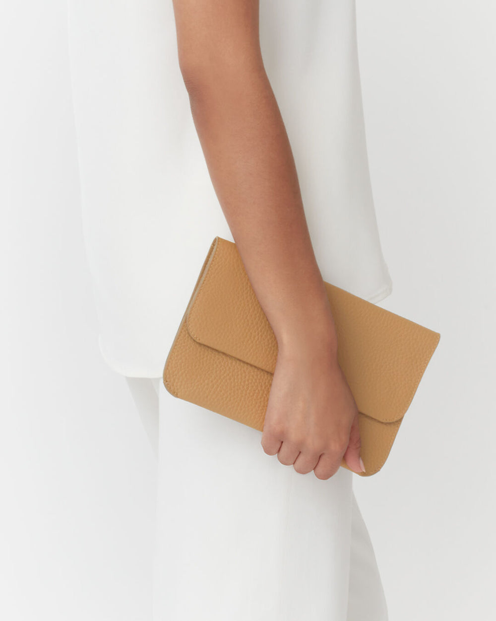 Person holding a clutch bag against their side