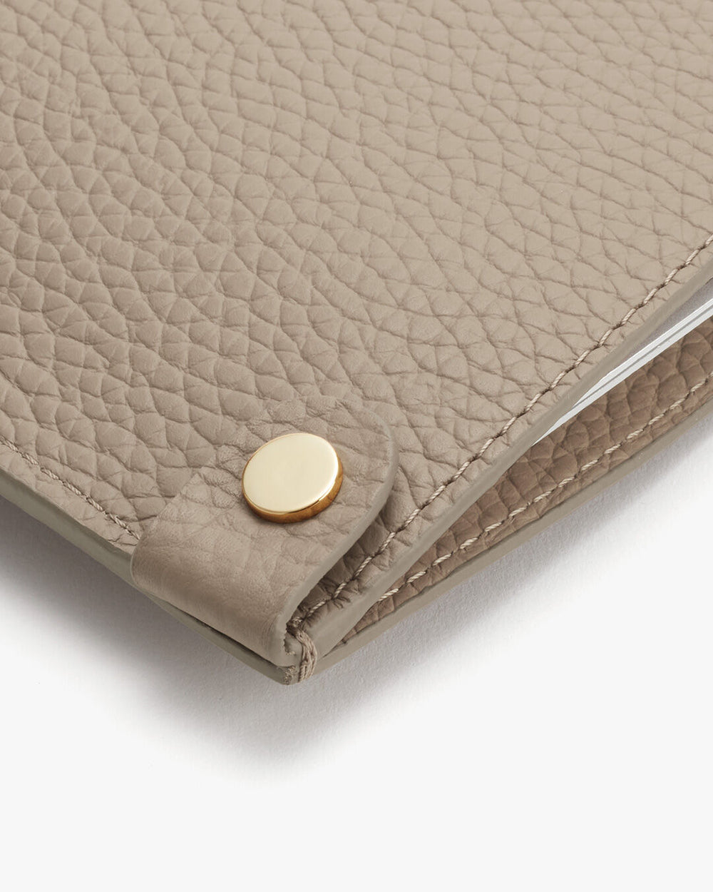 Close-up of a textured wallet with a snap button closure.