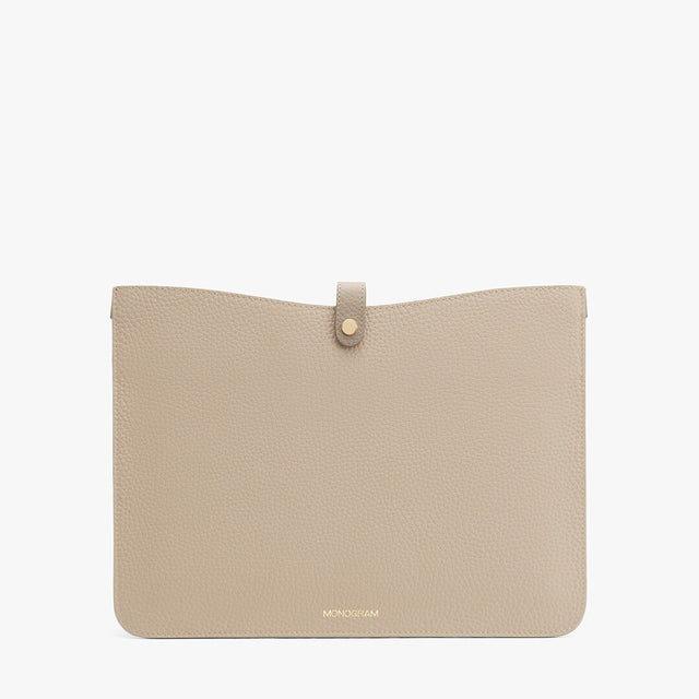 A plain clutch bag with a central tab closure and a branded logo at the bottom.