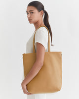 Woman in profile view carrying a large shoulder bag.