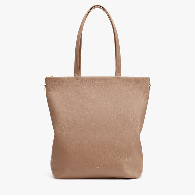 Leather tote bag with two handles and a zipper on a plain background.
