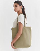 Woman carrying a shoulder bag, facing sideways.