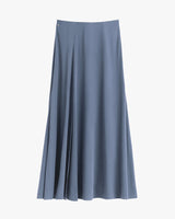Long pleated skirt hanging against a plain background.