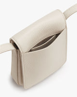 Small handbag with flap open, revealing interior.