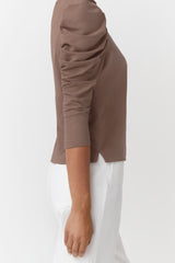 Woman wearing a half-sleeve top, shown from shoulder to waist.