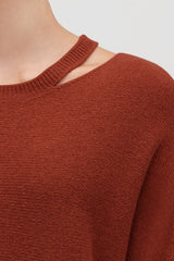 Close-up of a person wearing a sweater with a shoulder cut-out.