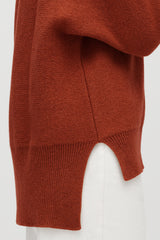 Close-up of a person wearing a sweater, side view of lower half.