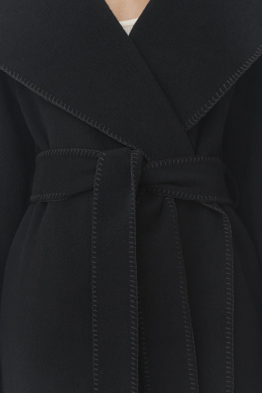 Close-up of a coat with a belted waist.