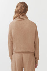 Person seen from behind wearing a turtleneck sweater and matching pants.